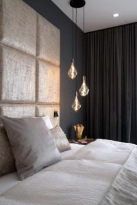 a bedroom with a white bed and two lights at THE NEWSHA SIGNATURE HOME in Mülheim an der Ruhr