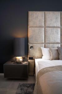 1 dormitorio con cama y mesita de noche con lámpara en THE NEWSHA SIGNATURE HOME, en Mülheim an der Ruhr