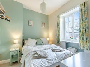 a bedroom with a bed and a window at Harvey Cottage in Colyton