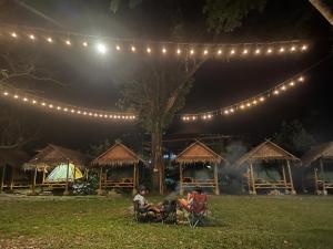 a person sitting in a chair under a group of lights at Khaosok Monkeys & River Camps in Khao Sok