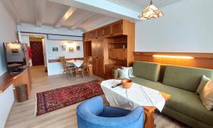 a living room with a couch and a table at ILSE Seeblick Appartement Haus Hänsel u Gretel am Ossiacher See, Hallenbad, Skiarena Gerlitzen in Manessen
