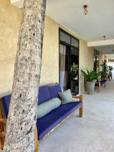 a blue couch sitting next to a tree at The Garden in Paje