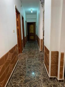 pusty korytarz z drzwiami i podłogą wyłożoną kafelkami w obiekcie Azzam Guest House 2 families only w mieście Fajum