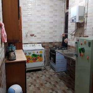 una piccola cucina con piano cottura e frigorifero di Azzam Guest House 2 families only a Fayoum