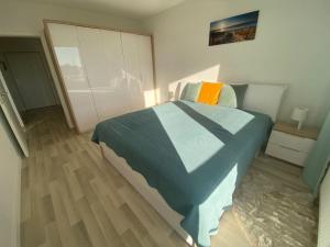 a bedroom with a blue bed and a wooden floor at Self check in with parking included in Bratislava