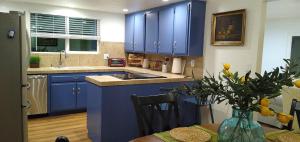 a kitchen with blue cabinets and a table with a vase at House, close to Downtown, St Helena, Kenwood in Santa Rosa
