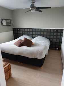 1 dormitorio con 1 cama y ventilador de techo en Bed & Breakfast d'Ouwe Smidse, en Kamperland