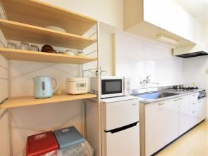 a small kitchen with white cabinets and a sink at Urban Life Matsuda - Vacation STAY 85183 in Okayama