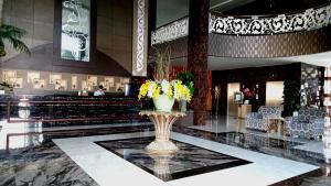 a lobby with a vase with flowers in it at Grand Bayu Hill Hotel in Takengon