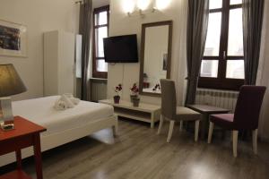 ein Hotelzimmer mit 2 Betten und einem TV in der Unterkunft Bronze Horse in Florenz