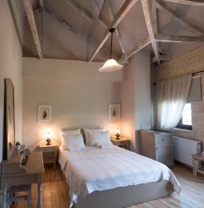 een slaapkamer met een groot bed met witte lakens bij Roptro in Dolianá