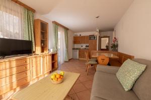 Residence Lagorai - Fiemme Holidays في بريدازو: غرفة معيشة مع أريكة وطاولة
