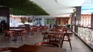 a restaurant with wooden tables and chairs and a bar at Grand Bayu Hill Hotel in Takengon