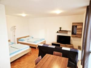 een woonkamer met 2 bedden en een tafel bij Apartments and Studios Perunika in Moravske-Toplice