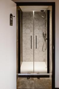 um chuveiro com uma porta de vidro na casa de banho em Hotel Chapter em s-Gravenzande