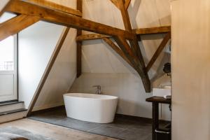 a bathroom with a white tub in a attic at Hotel Chapter in s-Gravenzande