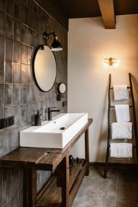 a bathroom with a white sink and a mirror at Hotel Chapter in 's-Gravenzande