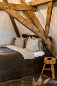 a bedroom with a black bed and a wooden table at Hotel Chapter in s-Gravenzande
