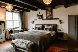 a bedroom with a large bed and a window at Hotel Chapter in 's-Gravenzande