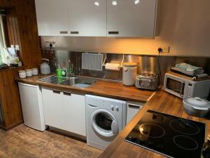 a kitchen with a sink and a washing machine at The Bay in Creggans