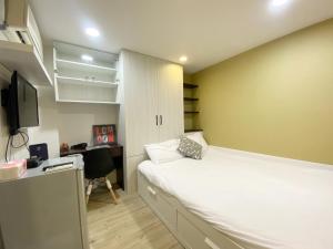 Habitación pequeña con cama y escritorio. en Day Day Fengjia en Taichung