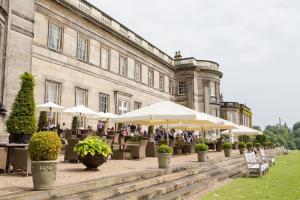 a courtyard with tables and umbrellas in front of a building at Dukeswood Cottage, Wynyard Hall in Grindon
