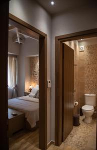 een slaapkamer met een bed en een badkamer met een toilet bij Roptro in Dolianá