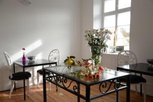 una sala da pranzo con due tavoli e un vaso con fiori di Alte Apotheke Bed & Breakfast a Karlsbad
