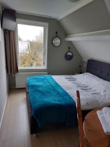 Un dormitorio con una cama grande y una ventana en Bed & Breakfast d'Ouwe Smidse, en Kamperland