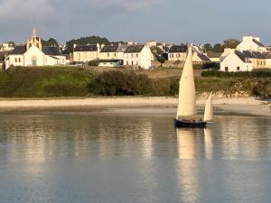 a small sail boat in the water near a beach at Appartement de charme - Port d'Audierne in Audierne
