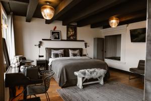 a bedroom with a bed and a table and chairs at Hotel Chapter in 's-Gravenzande