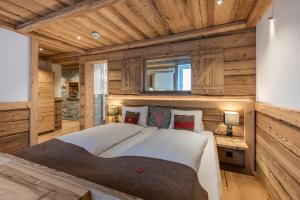 een slaapkamer met een groot bed in een kamer met houten wanden bij Hotel Crusch Alba Zernez in Zernez