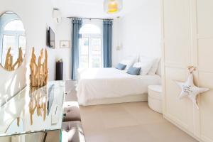 a white bedroom with a bed and a window at DIEPEDALE - 3 PIECES - PARKING - Carré d'or Menton in Menton