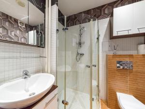 a bathroom with a sink and a glass shower at Nowogrodzka Cozy Studio II in Warsaw