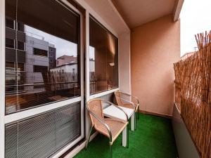 a balcony with two chairs and a large window at Nowogrodzka Cozy Studio II in Warsaw
