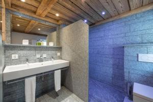 ein Bad mit einem Waschbecken und einer Dusche in der Unterkunft Hotel Crusch Alba Zernez in Zernez