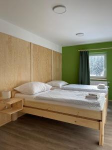 łóżko w pokoju z zieloną ścianą w obiekcie Penzion Mája w mieście Josefuv dul