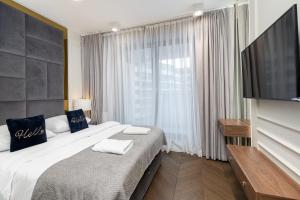 a bedroom with a large bed and a large window at GA Luxury Apartments G244 in Krakow