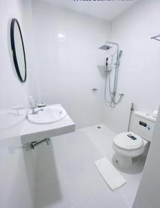 uma casa de banho branca com um lavatório e um WC em White Seaview Residence em Klong Muang Beach