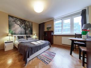 a bedroom with a bed and a table and a desk at Sliska 10 apartament in Warsaw