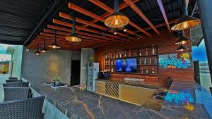 a kitchen with a bar with a tv on a brick wall at Aloha Boracay Hotel in Boracay
