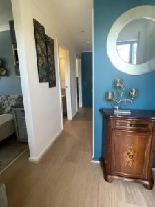 Zimmer mit blauen Wänden und einem Tisch mit einem Spiegel in der Unterkunft New & adorable unit close to the beach in Aspendale