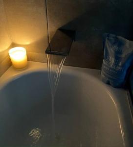 a stream of water coming out of a bath tub with a candle at New & adorable unit close to the beach in Aspendale