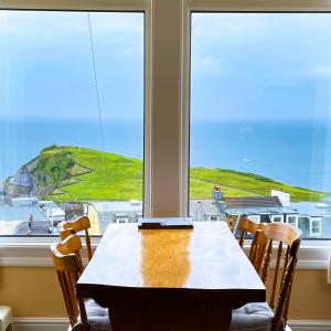 a dining room table with a view of the ocean at Ocean View in Ilfracombe