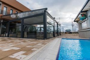 a glass extension of a house with a swimming pool at Solay in Oradea