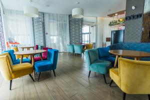 a restaurant with tables and chairs in a room at Solay in Oradea