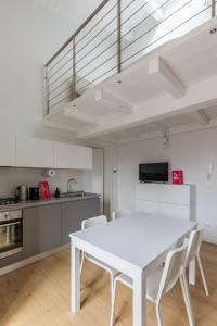 uma cozinha com uma mesa branca e cadeiras num quarto em Appartamento a Porta Lame by Wonderful Italy em Bolonha