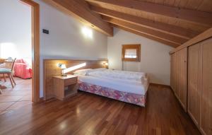 Residence Lagorai - Fiemme Holidays في بريدازو: غرفة نوم بسرير كبير وارضية خشبية
