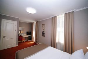 a bedroom with a bed and a room with a desk at Sharden Villa Boutique Hotel in Tbilisi City