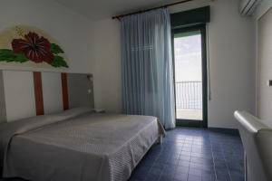 a bedroom with a bed and a large window at Capo Skino Park Hotel in Gioiosa Marea